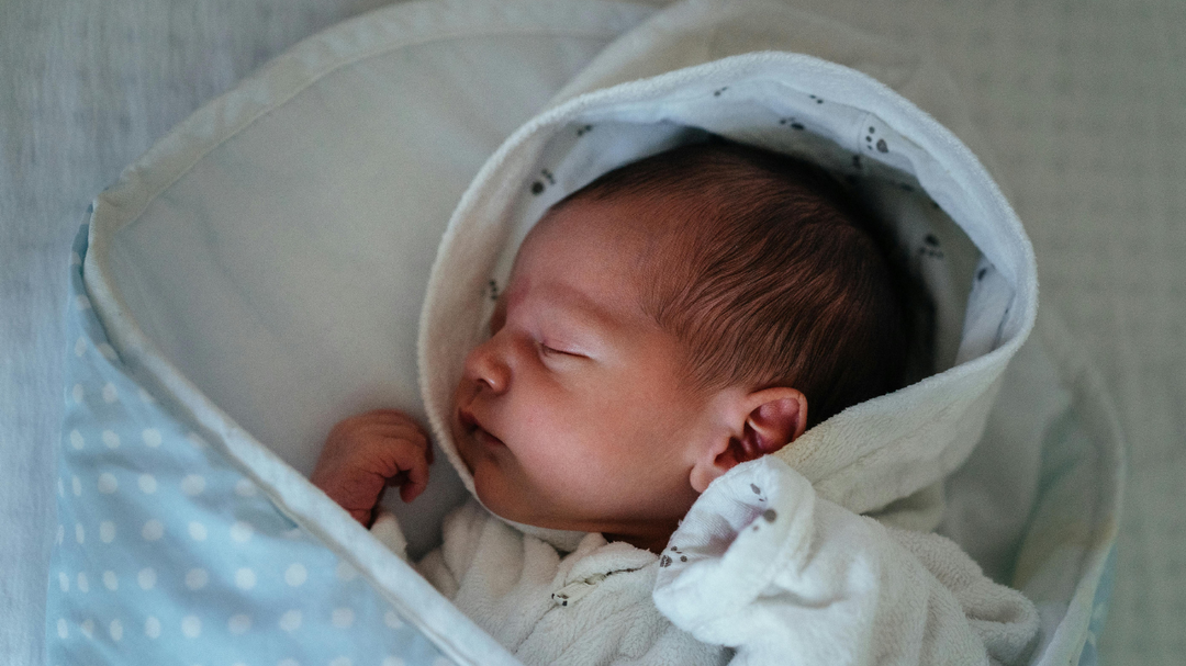 Baby sleeping to show how creating a calming bed routine can help babies sleep